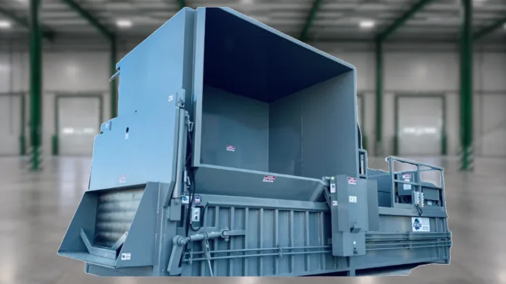 Pre-crusher compactor with a large loading hopper in a warehouse