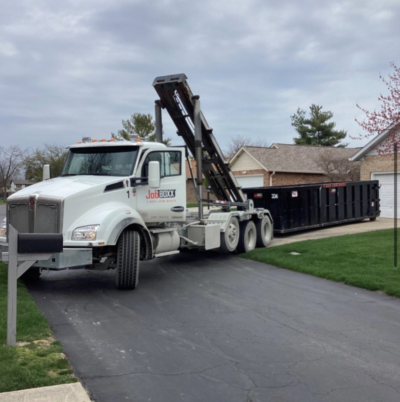 Delivering a roll-off container to a driveway