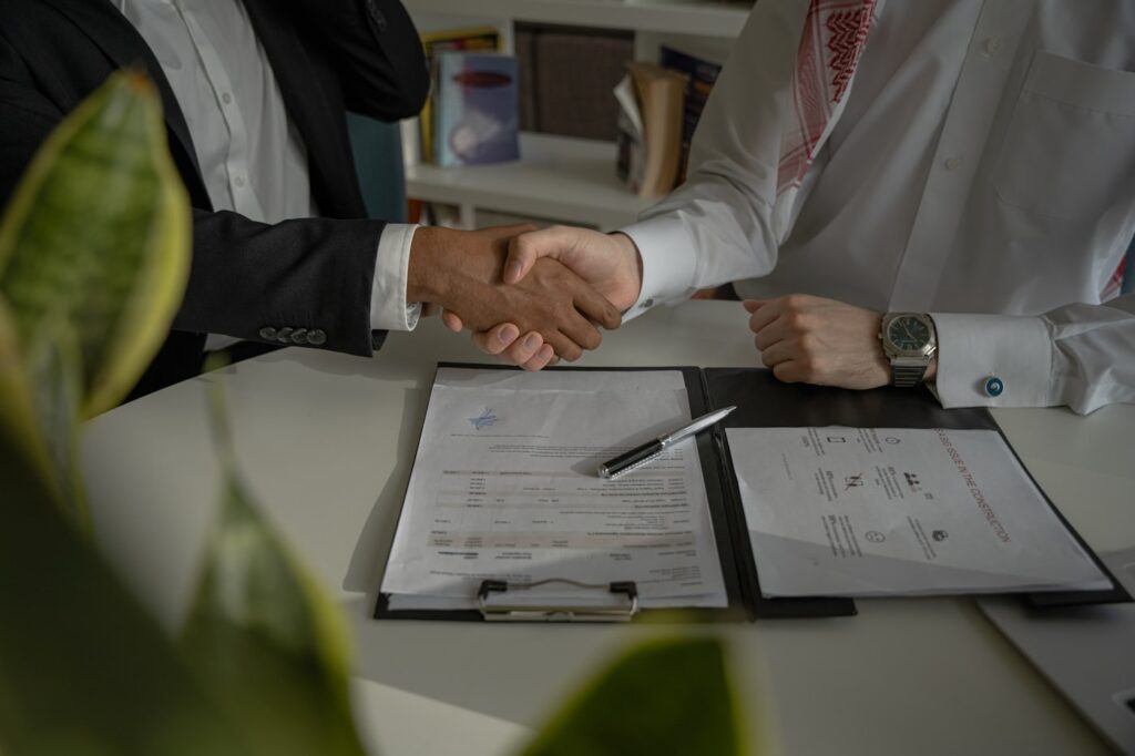 Two people reviewing printed invoices at a table