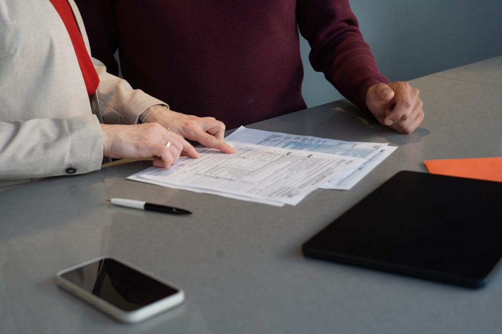 A person reviewing a printed invoice at a desk